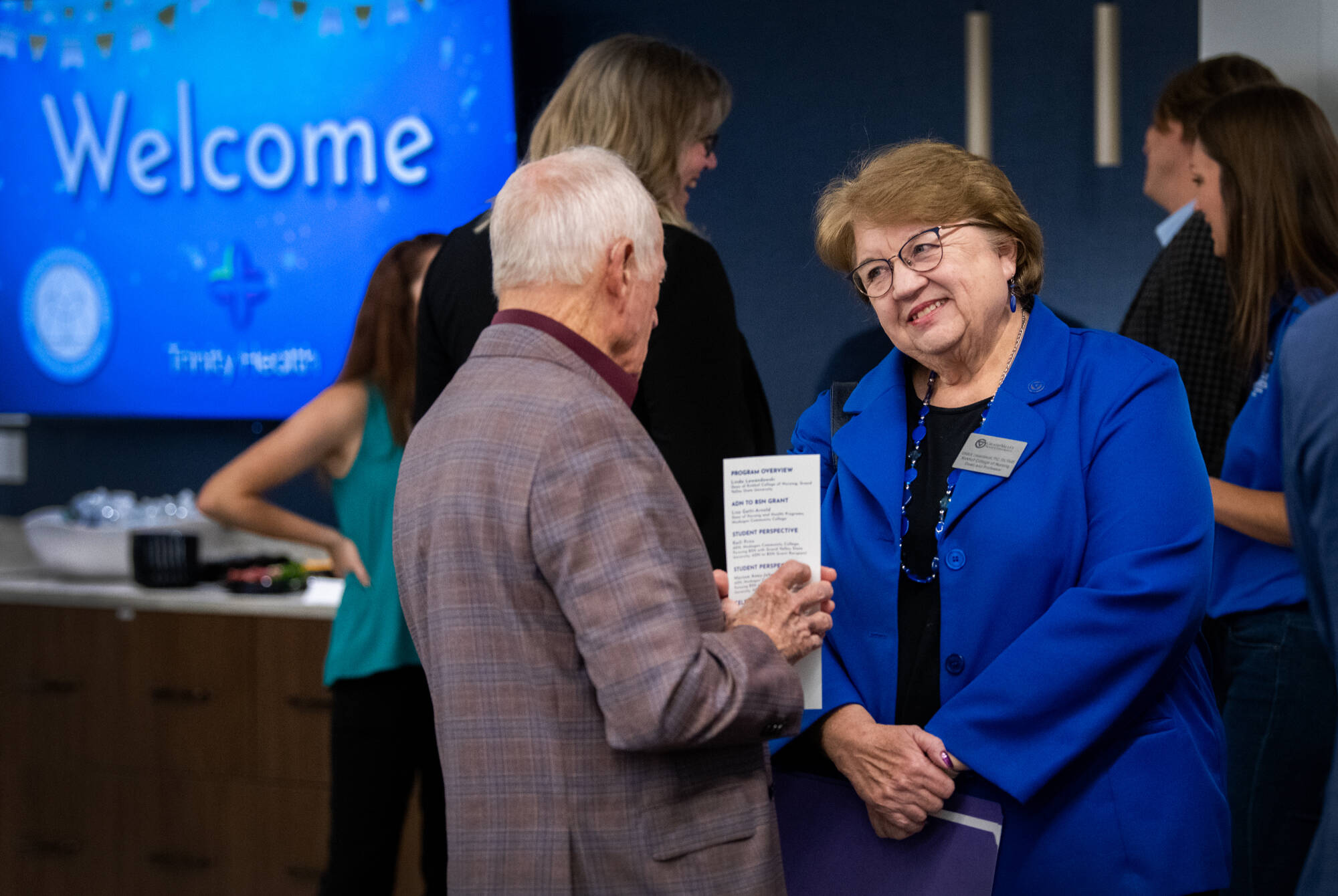 Linda Lewandowski, dean of the Kirkhof College of Nursing, right, speaks with Muskegon Community College board trustee Don Crandall, left, during an event at Trinity Health Muskegon Hospital celebrating the nursing partnership October 29.